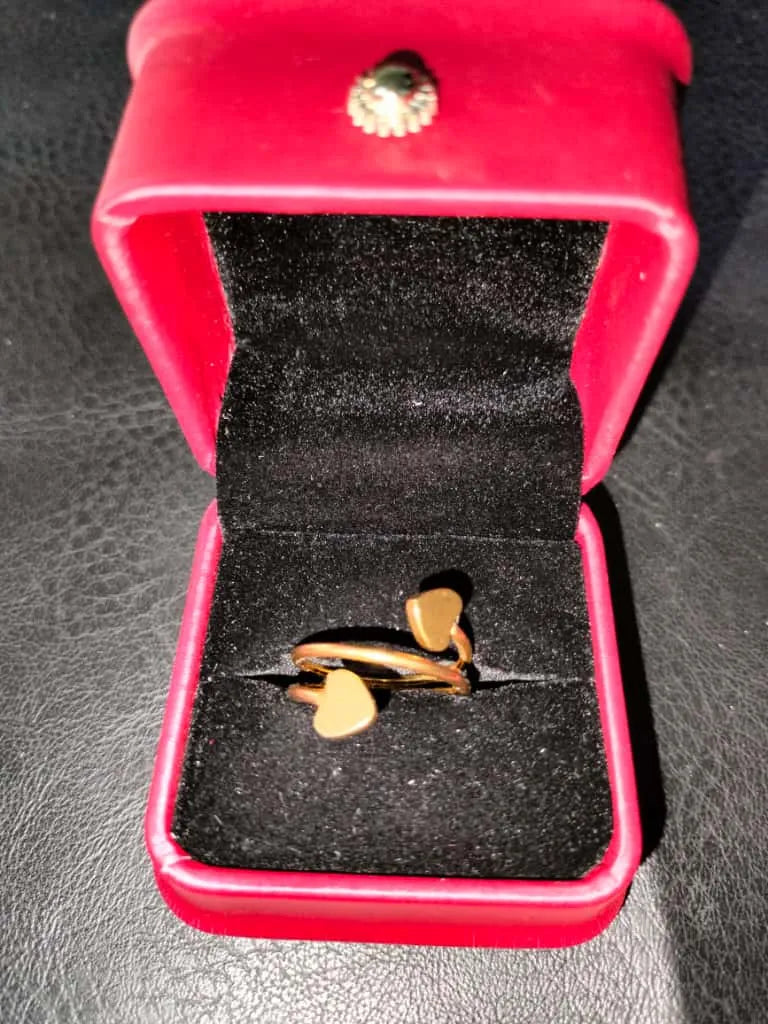 Gold ring in a red box on a dark surface