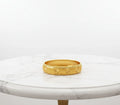 Gold bracelet on a marble surface
