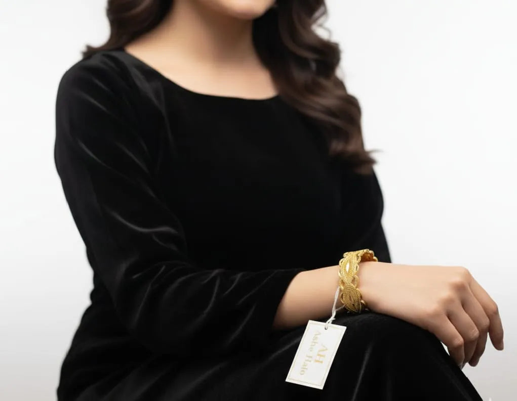 Person wearing a black outfit with a tag on a white background