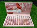 Set of 3Q beauty lip glosses in a display case on grass