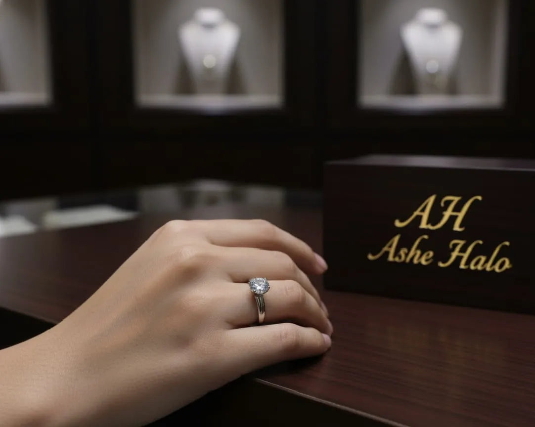 Hand wearing a ring with 'AH Ashe Halo' branding in a jewelry store setting