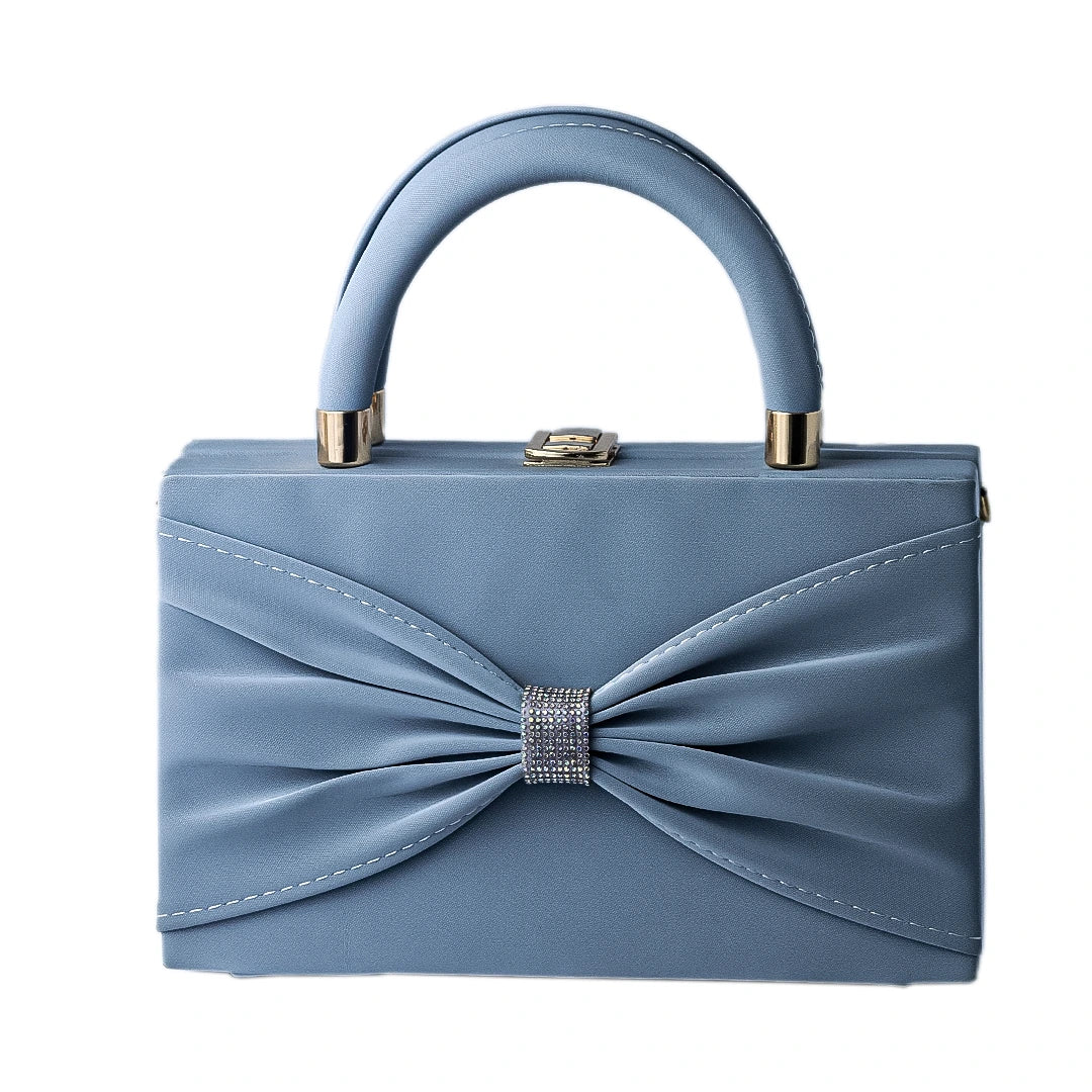 Blue handbag with a decorative bow on a white background