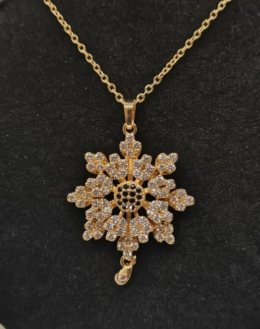 Gold snowflake pendant necklace on a black background