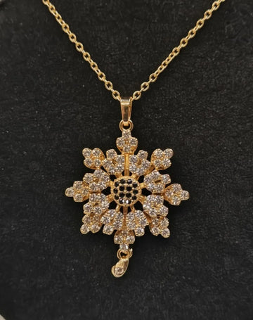 Gold snowflake pendant necklace on a black background