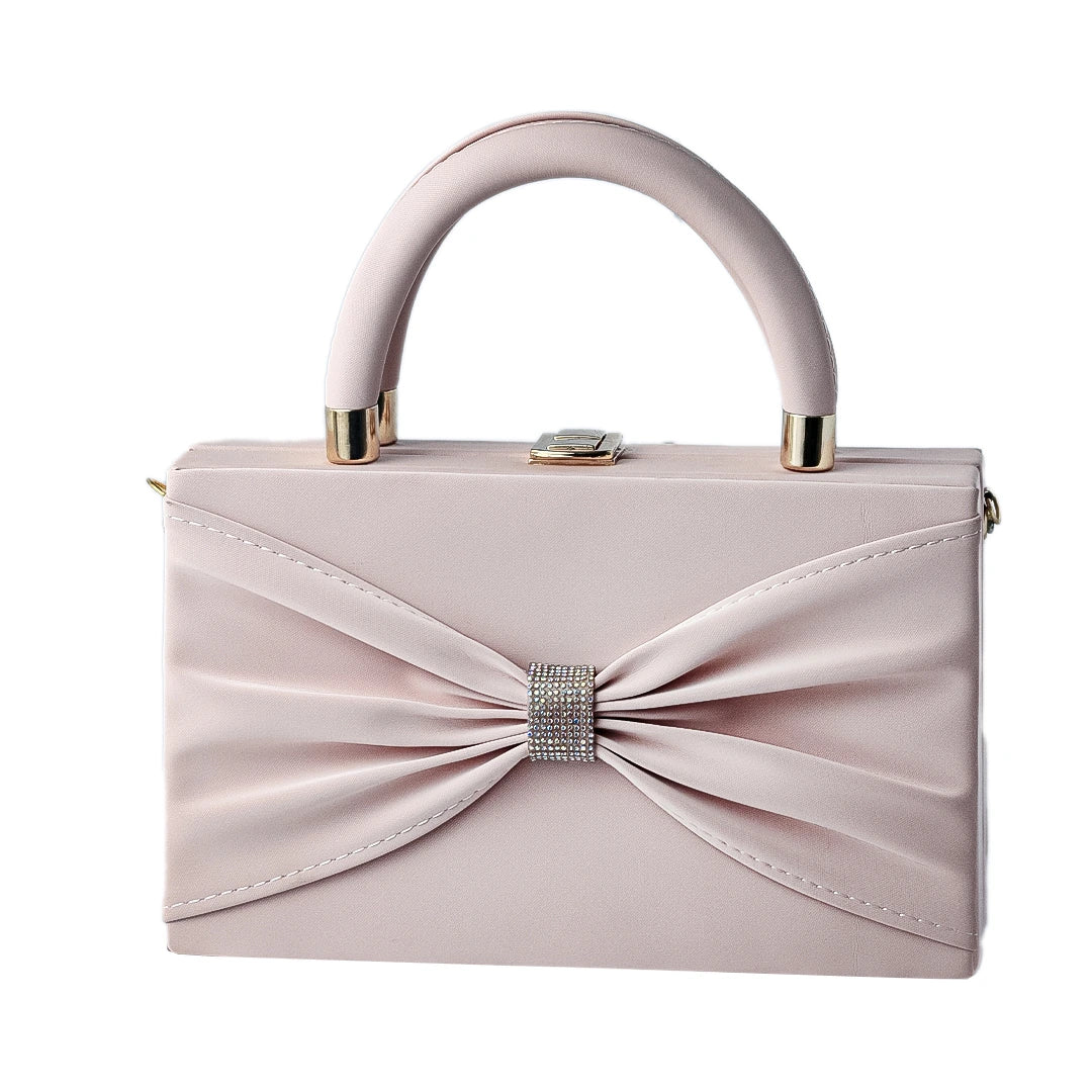 Pink handbag with a bow and crystal detail on a water surface