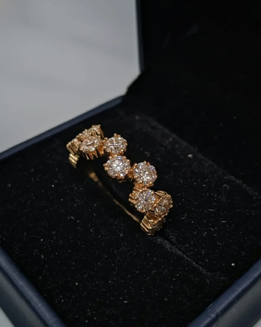 Close-up of a hand wearing a diamond ring on a neutral background