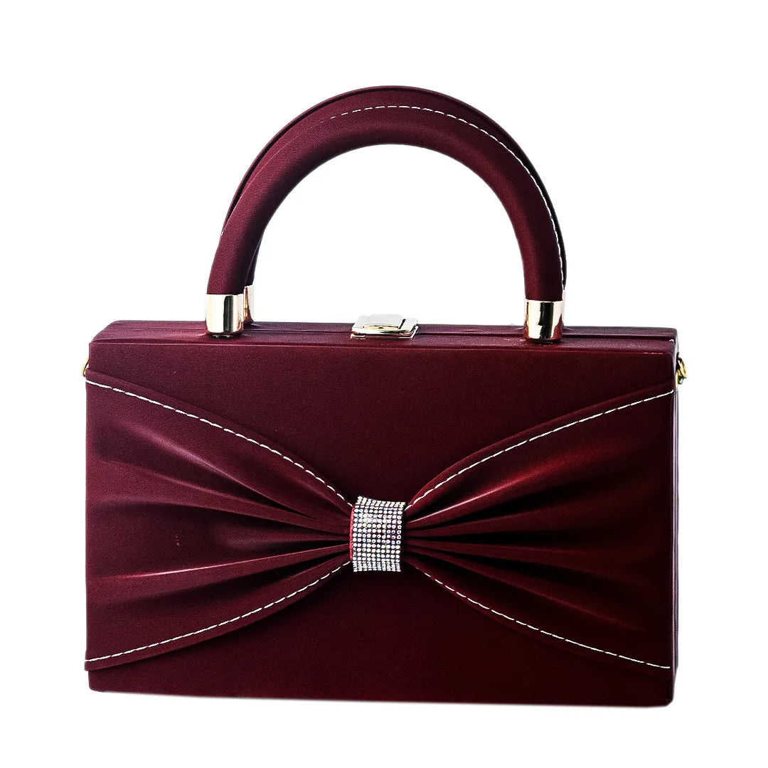 Red handbag with a bow on a reflective surface