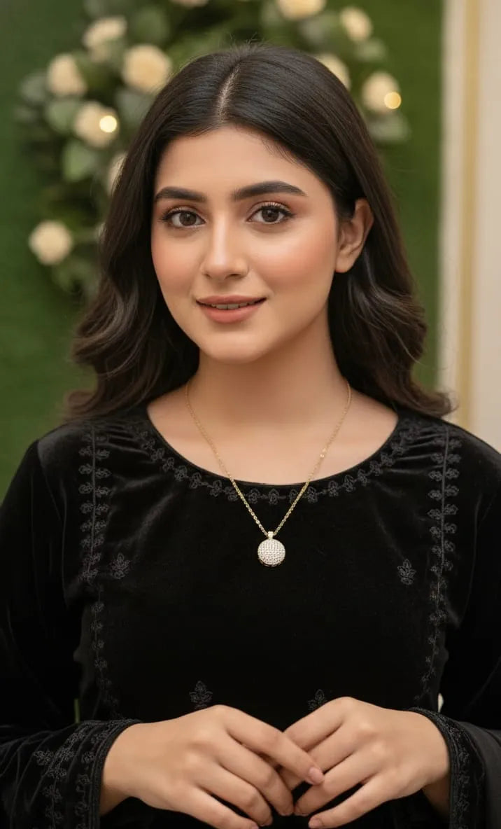 Gold necklace with a round, diamond-studded pendant on a black background