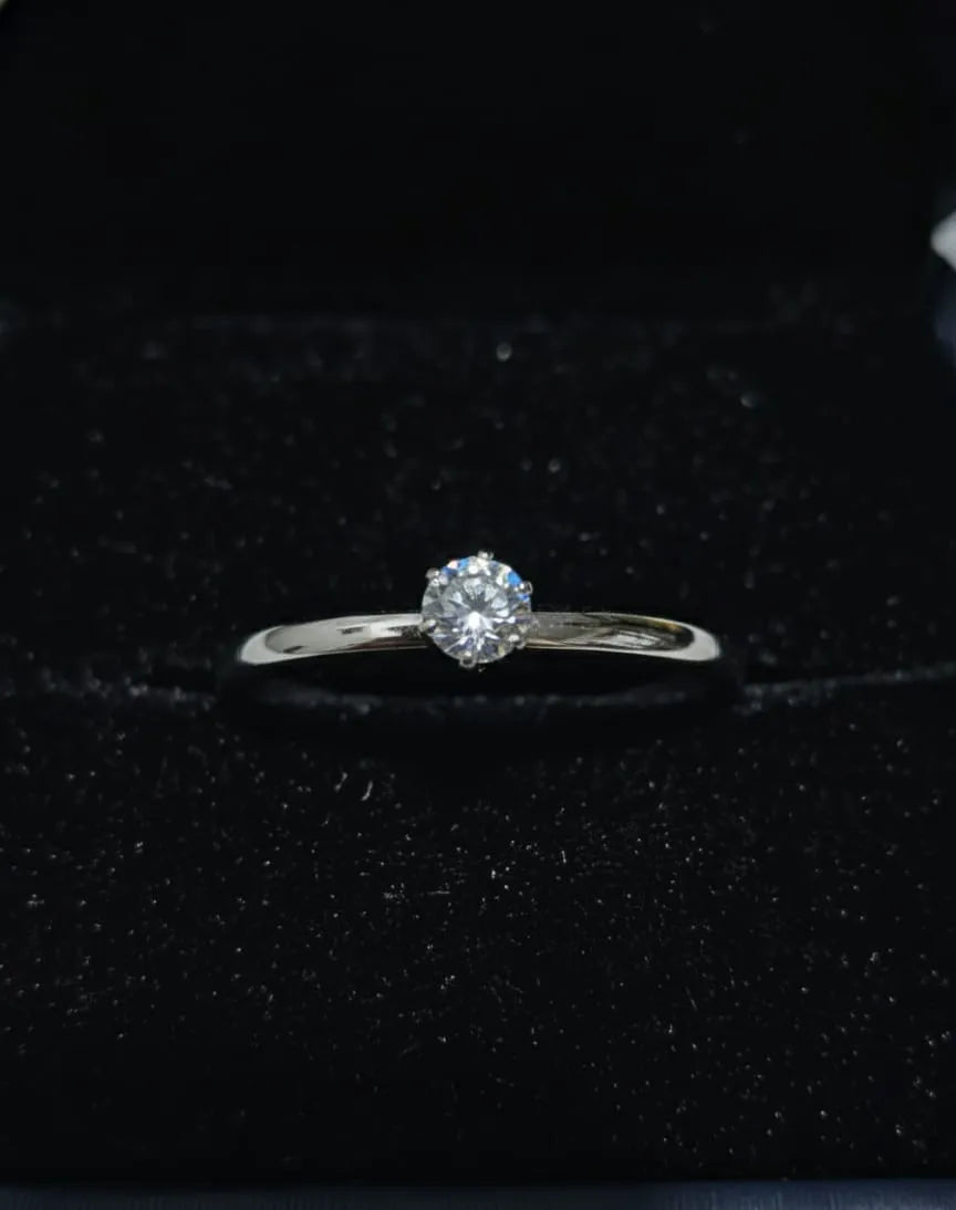 Woman in traditional attire holding hand with ring, floral and architectural background