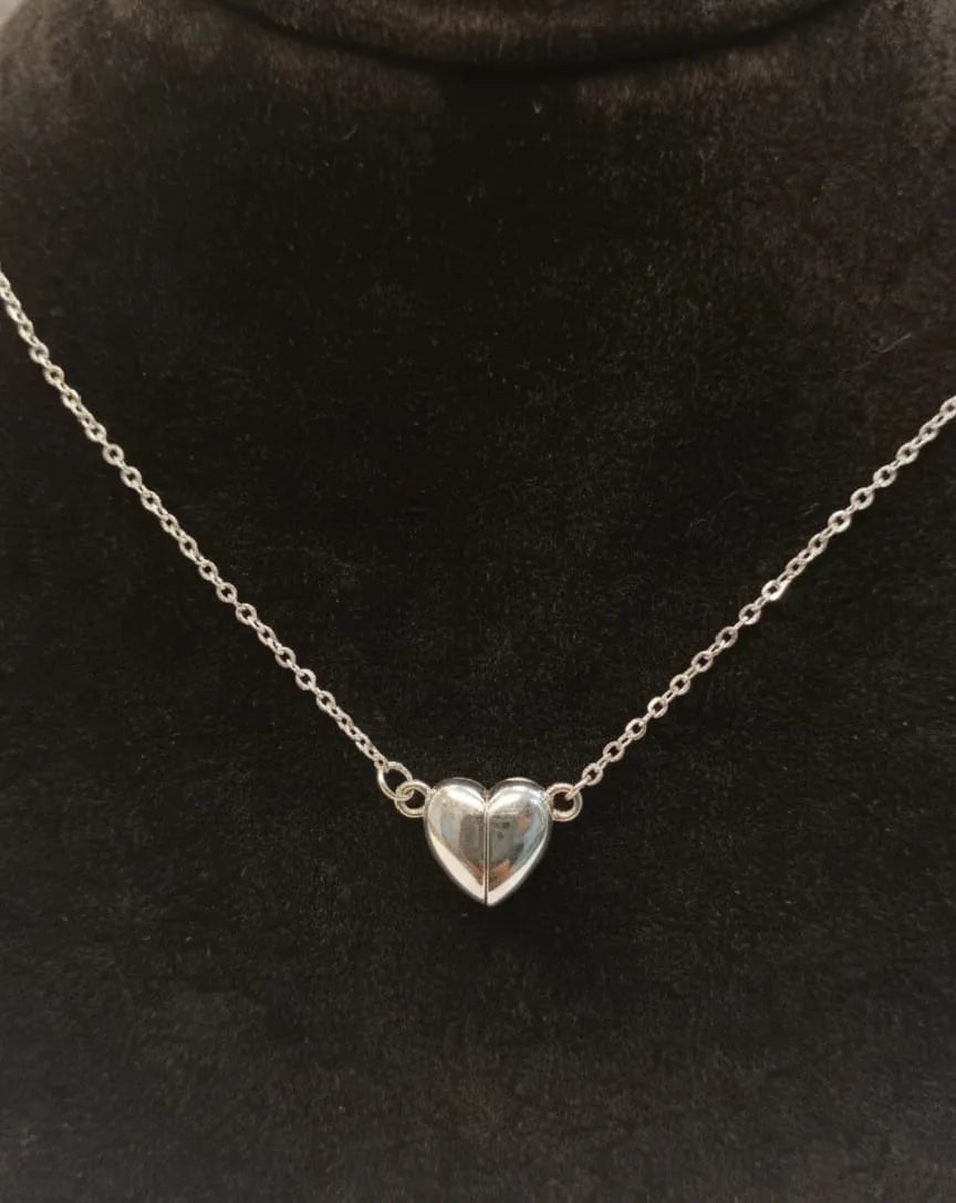 Silver heart-shaped pendant necklace on a black background