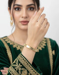 Woman wearing a gold bracelet on a white background