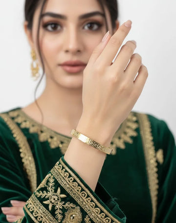 Woman wearing a gold bracelet on a white background