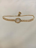 Gold bracelet with a diamond clasp on a light background