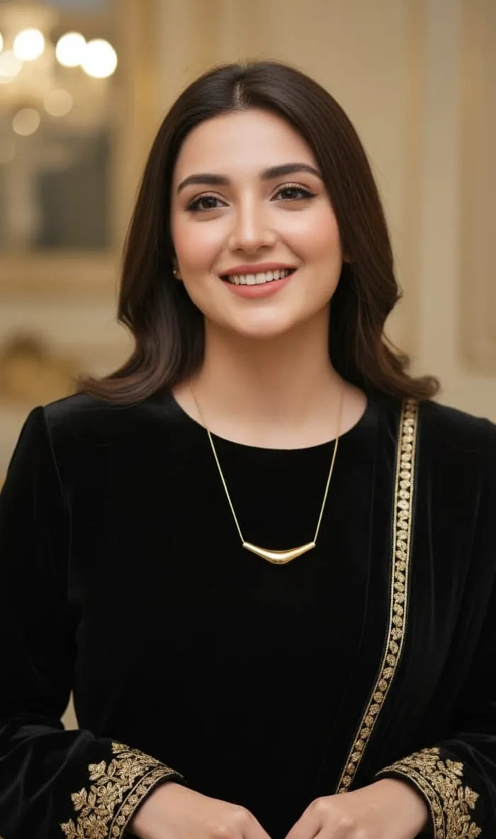 Woman wearing a black outfit with gold accents indoors
