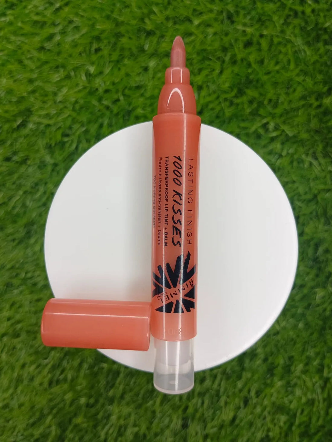 Lip liner pen on a white stand with grass background