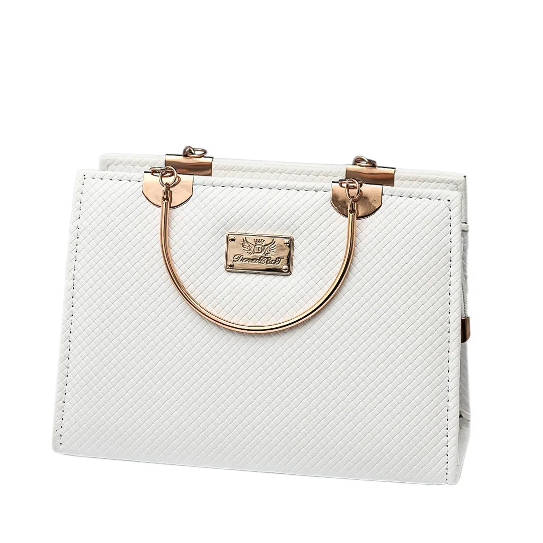 White handbag with gold accents on a black marble table against a beige background