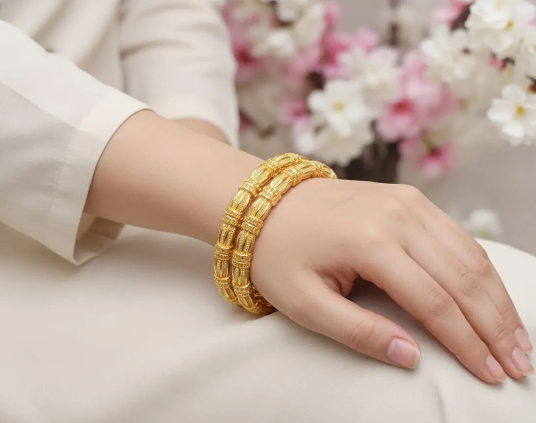 Gold bracelet on a hand with a blurred floral background