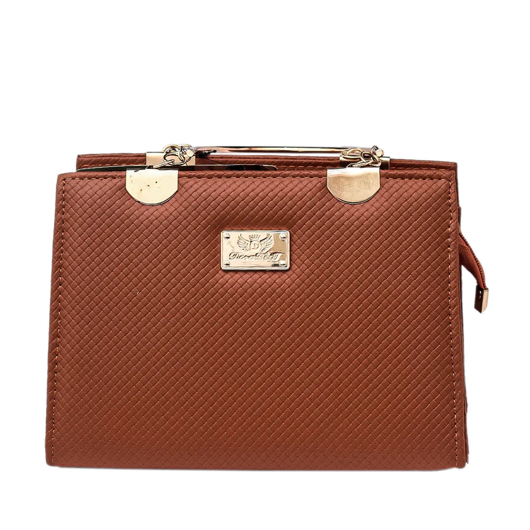 Brown textured handbag on a round black marble table with green plants in the background