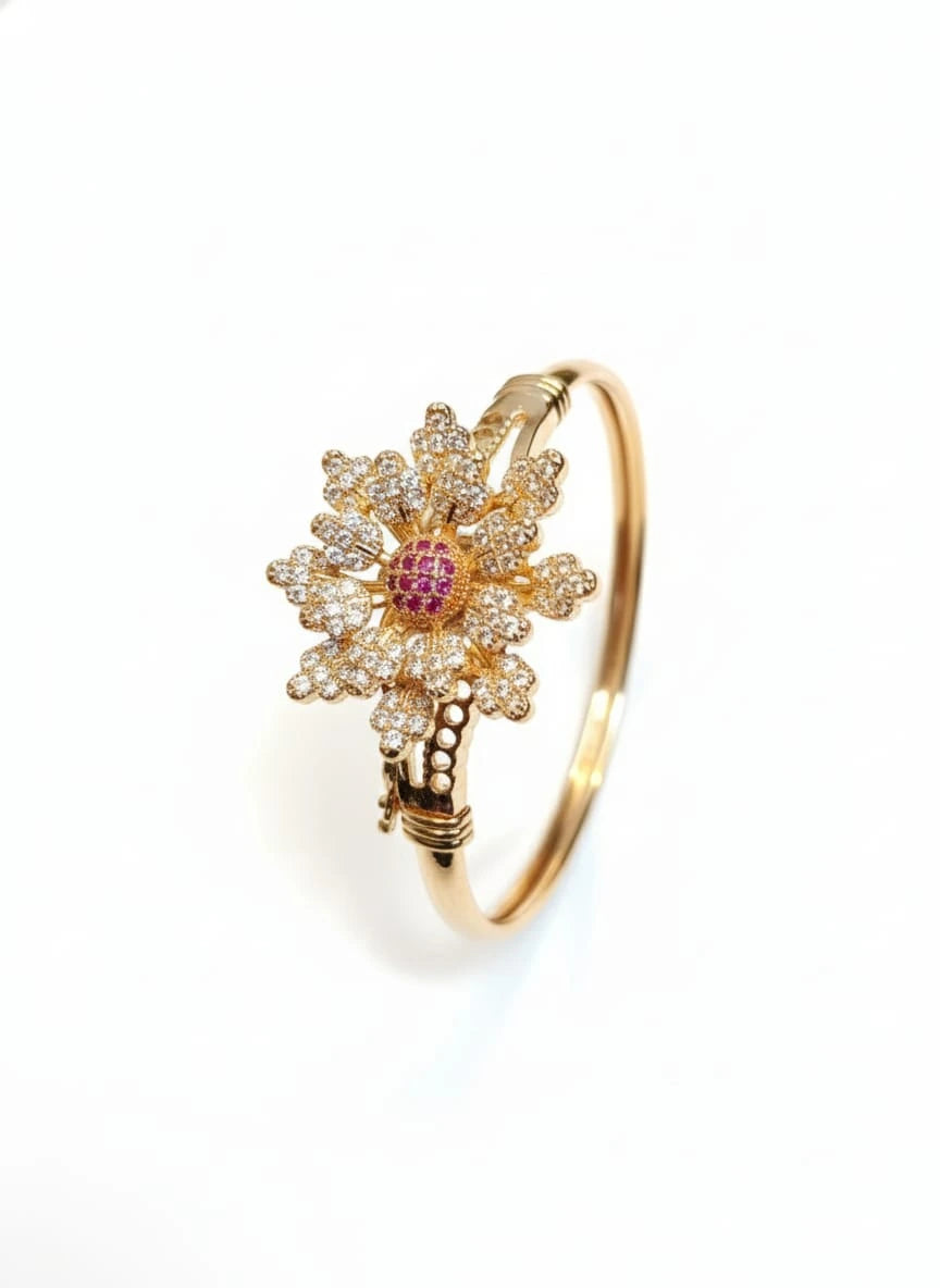 Gold flower-shaped bracelet with a pink gemstone on a white background