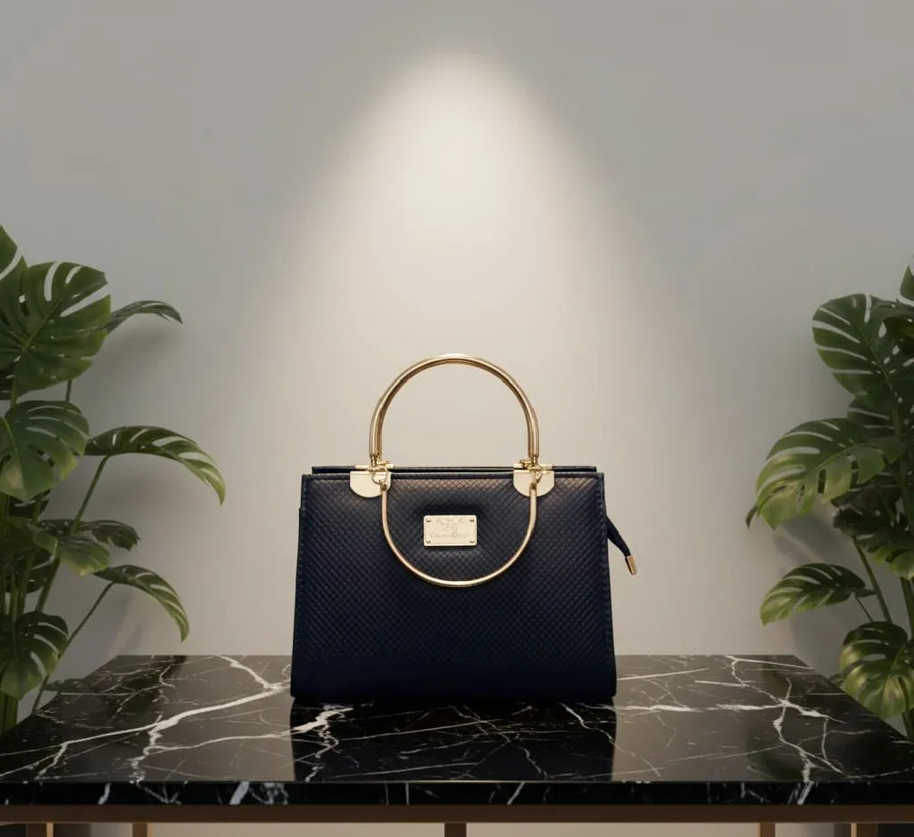 Black handbag with gold accents on a marble surface, flanked by plants.