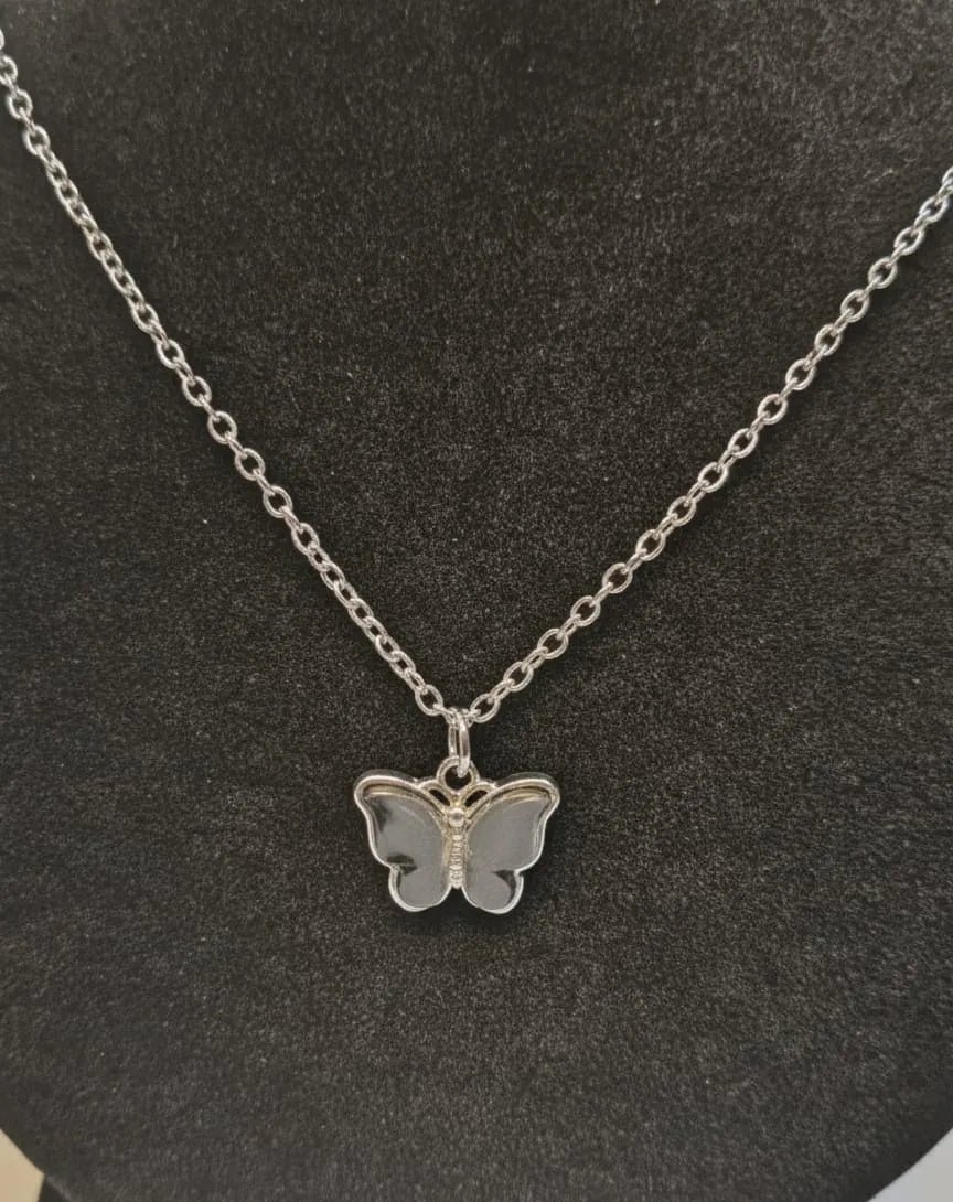 Silver butterfly necklace on a dark gray background