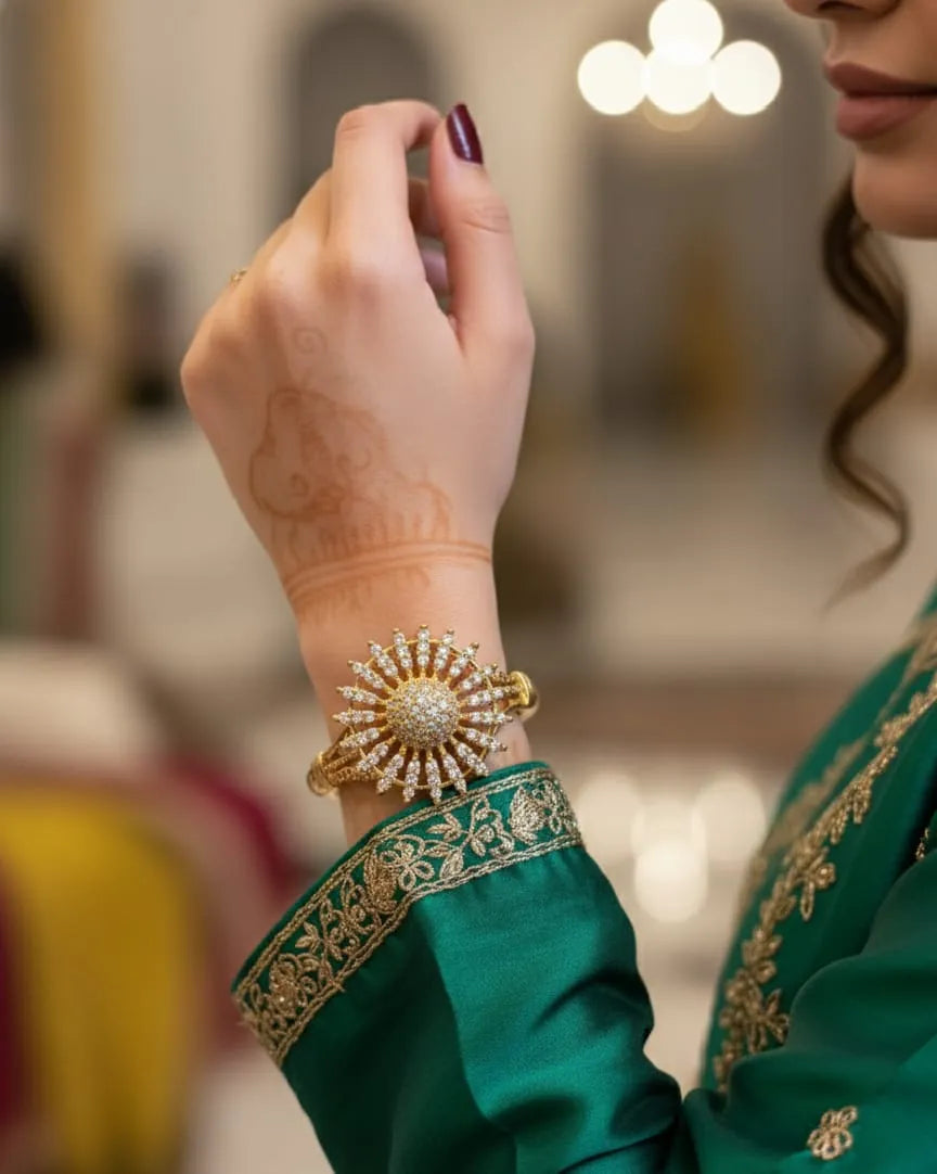 Woman wearing a gold bracelet on a blurred indoor background