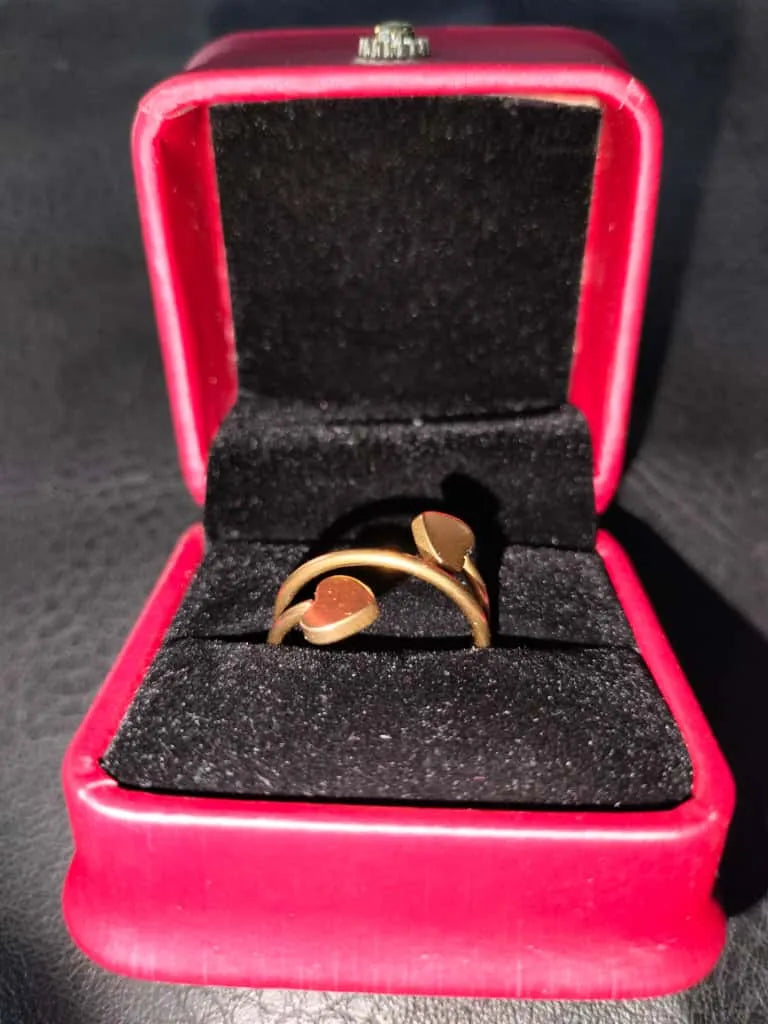 Gold ring in a red box on a dark surface