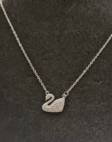 Silver swan pendant necklace on a dark textured background
