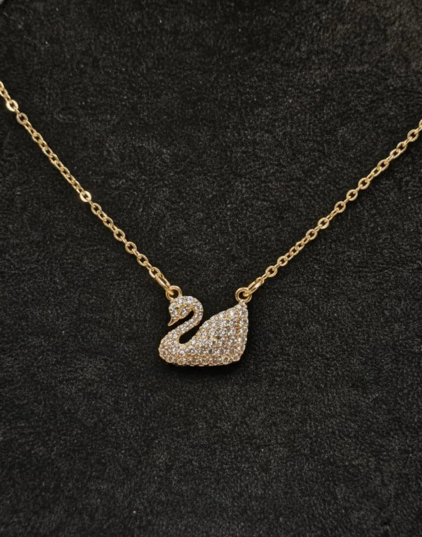 Gold necklace with a swan pendant on a black background