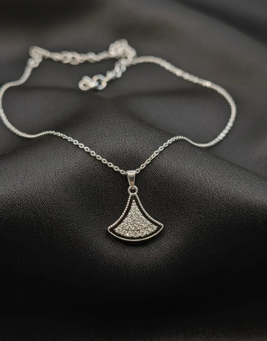 Silver necklace with a pendant on a dark fabric background
