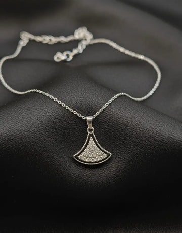 Silver necklace with a pendant on a dark fabric background