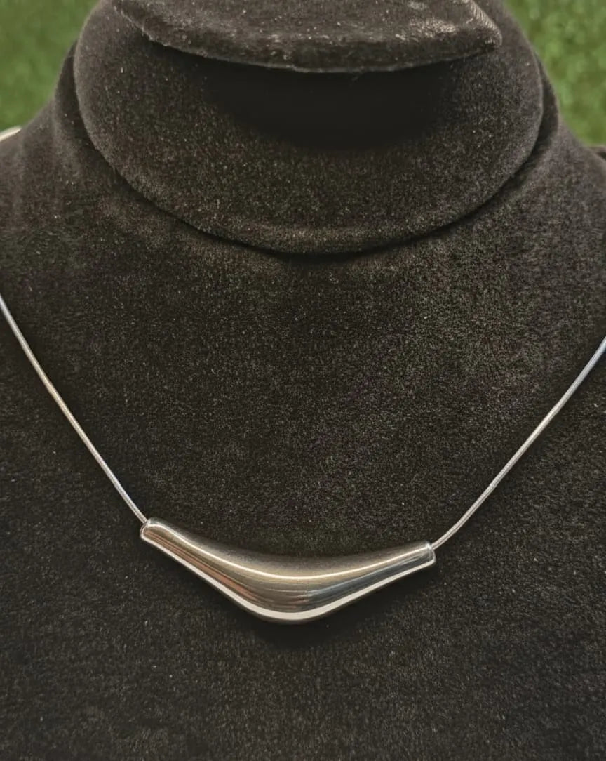 Silver necklace on a dark brown fabric background