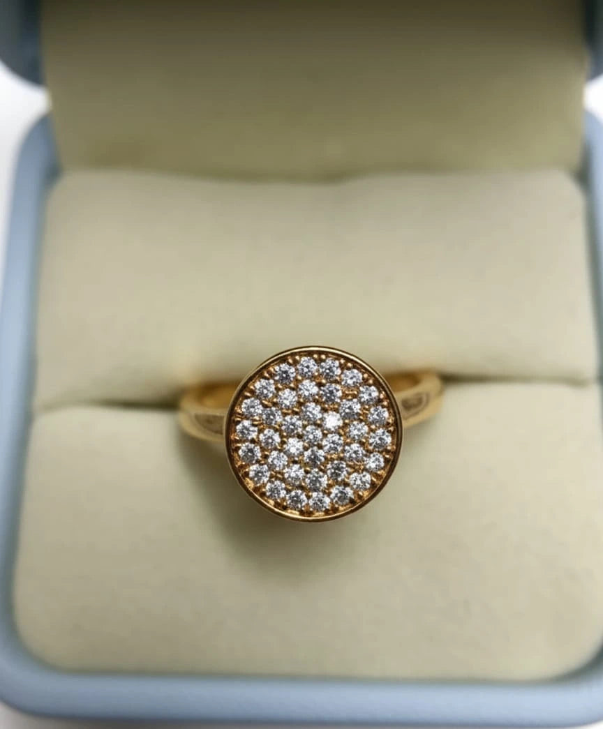 Gold ring with 'AH Ashe Halo' on a gray jewelry box in a store setting
