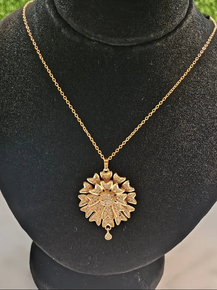 Gold necklace with a star-shaped pendant on a black mannequin bust.