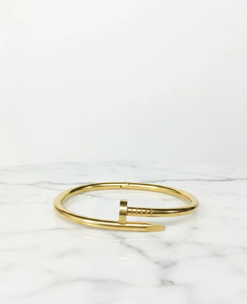 Gold bracelet on a marble surface